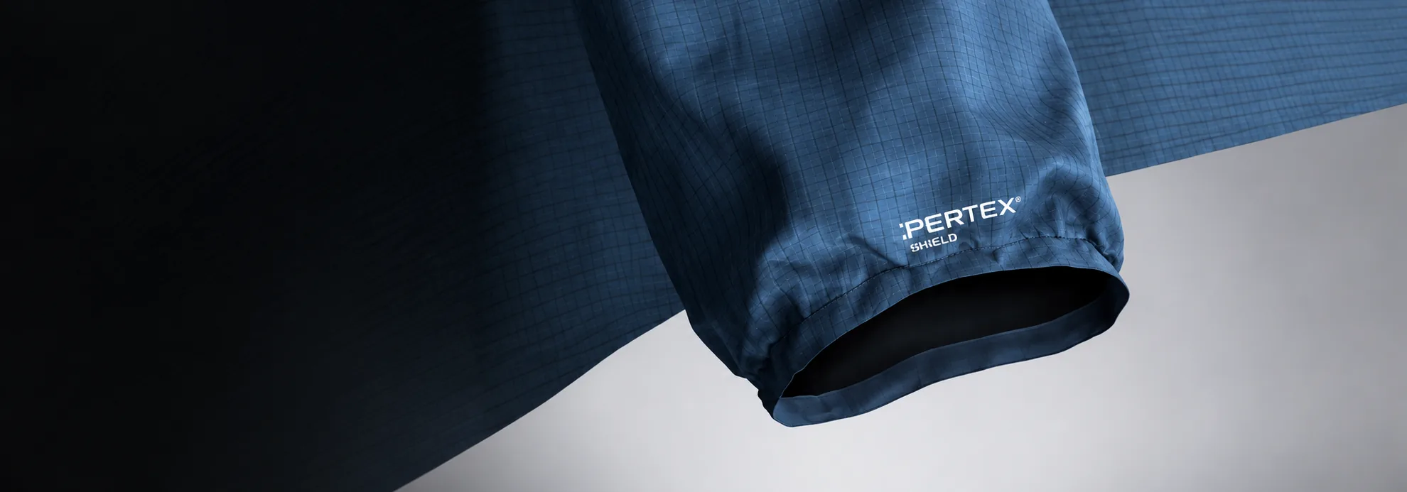 Close up of a blue sleeve cuff with the PERTEX SHIELD label